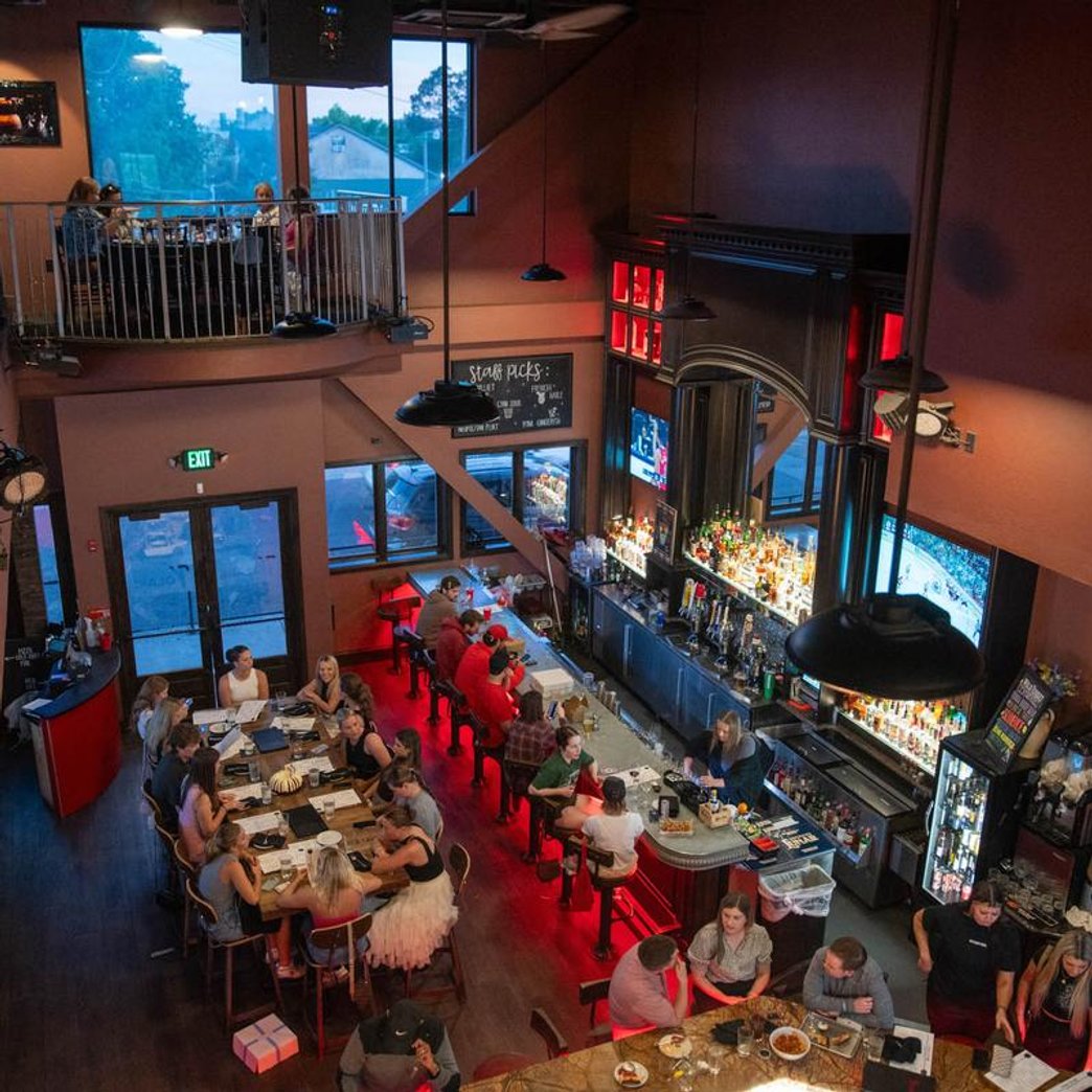 Restaurant with a mezzanine well-stocked bar and guests seated at tables